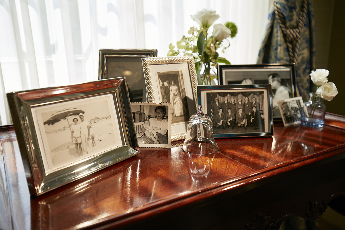 A collage of vintage photographs sit on a wooden desk.
